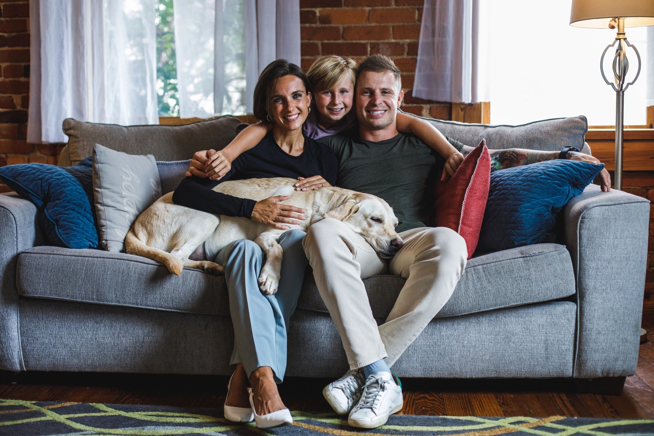 Family relaxing with their dog on a sofa